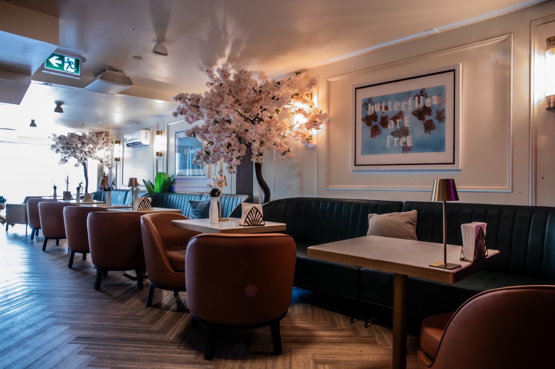 Banquette seating beneath blossom canopy at Yorkville Lounge